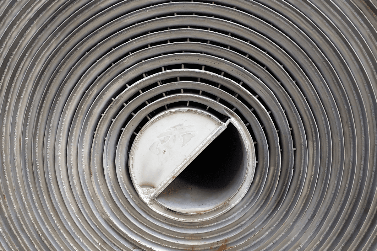 Close-up of a circular metal grate with a central rotating dial.