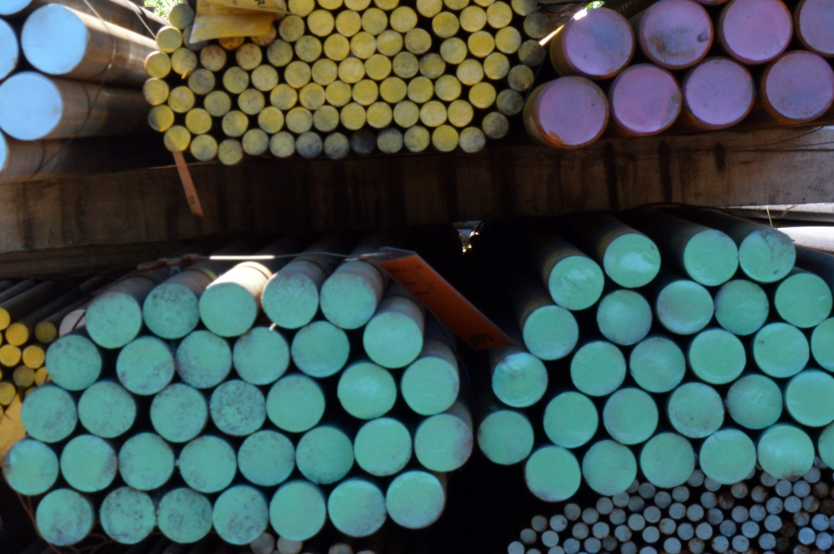 Stacks of colored cylindrical pipes organized in rows.