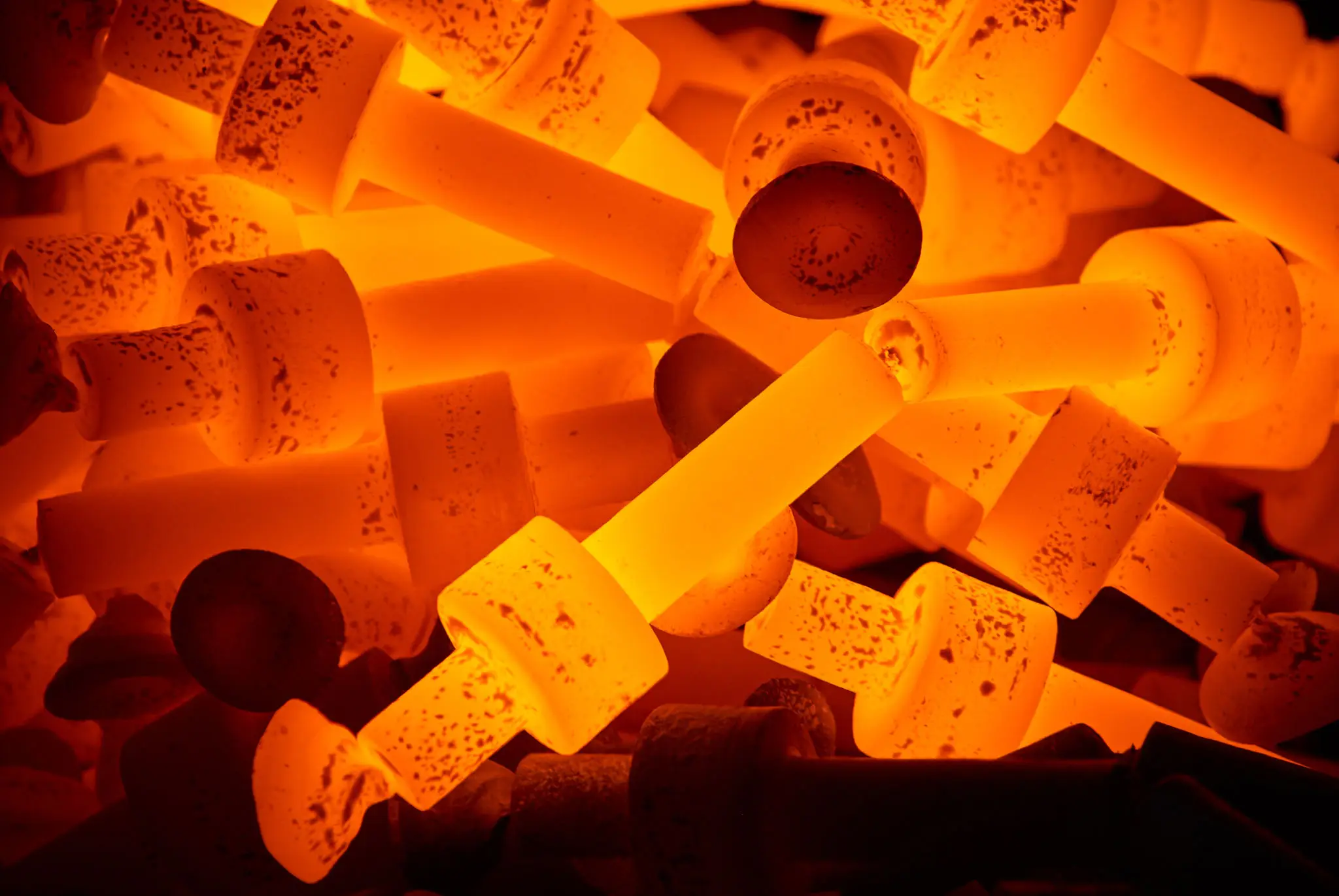 A collection of wine corks illuminated with warm orange light.